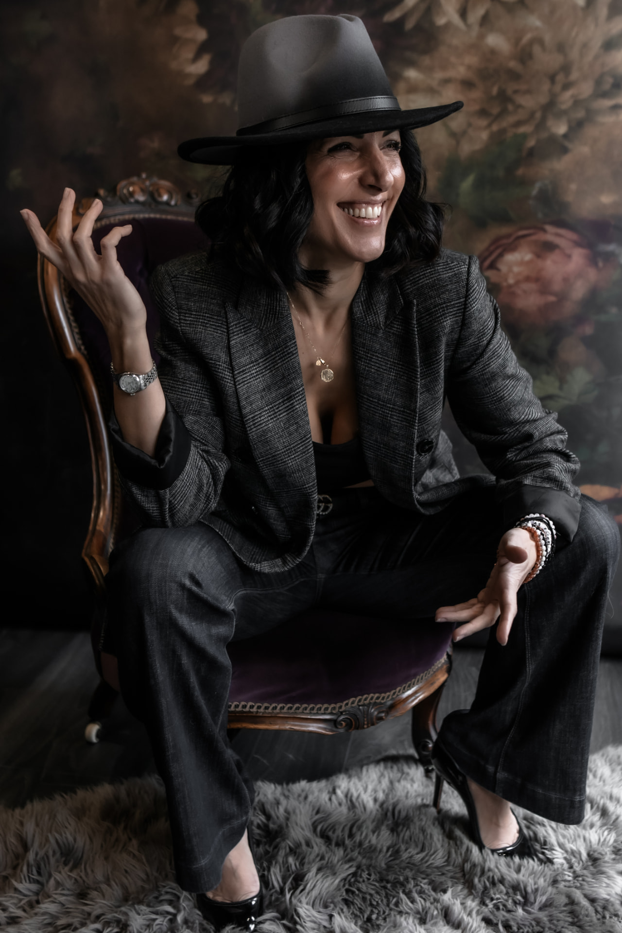 Naomi Buff laughing in conversation, seated in a velvet chair